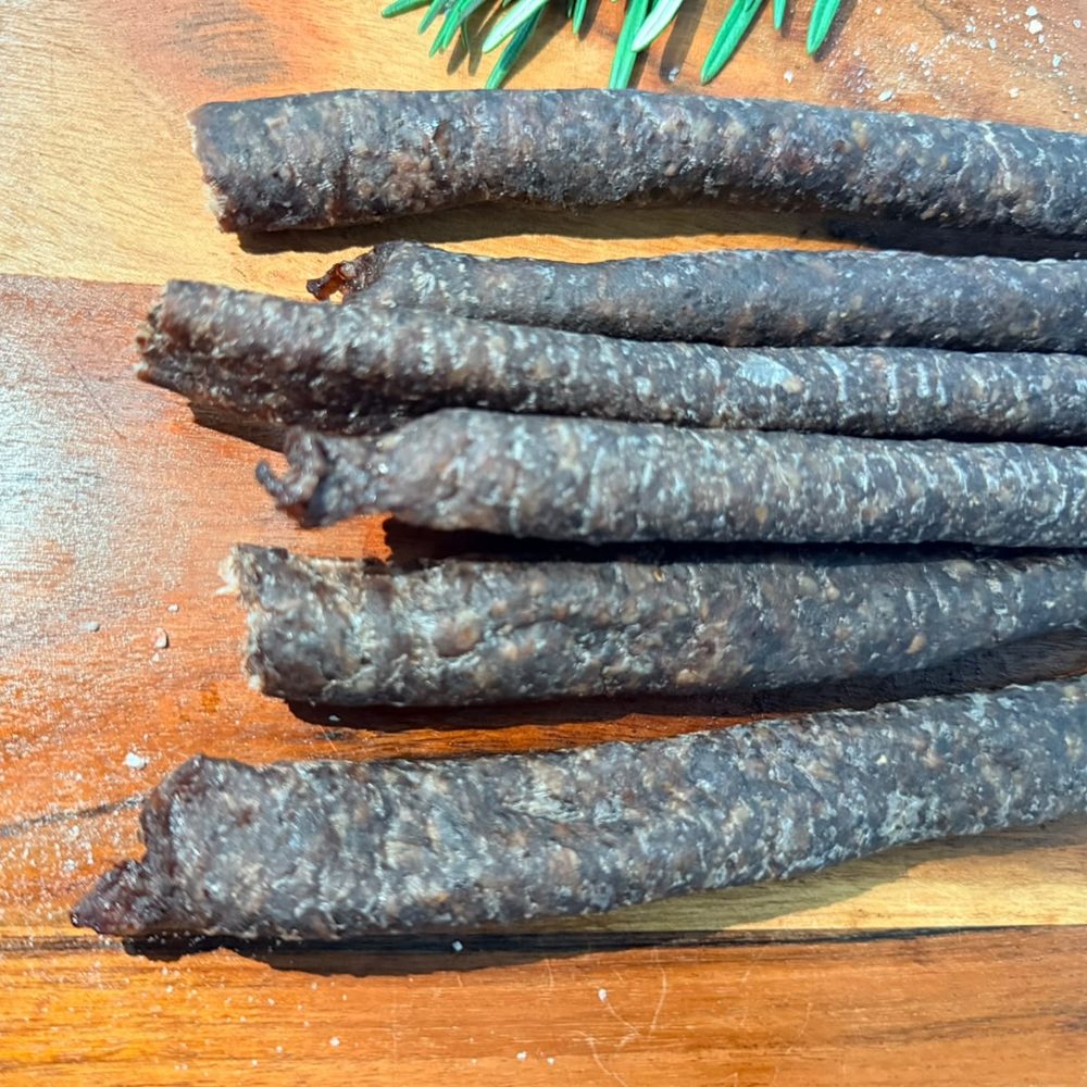 Artisan droëwors sticks laid out on a wooden board